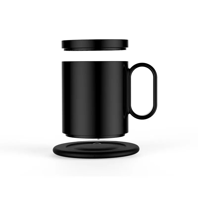 Black wireless charging warm cup on desk next to smartphone, showing USB cable.