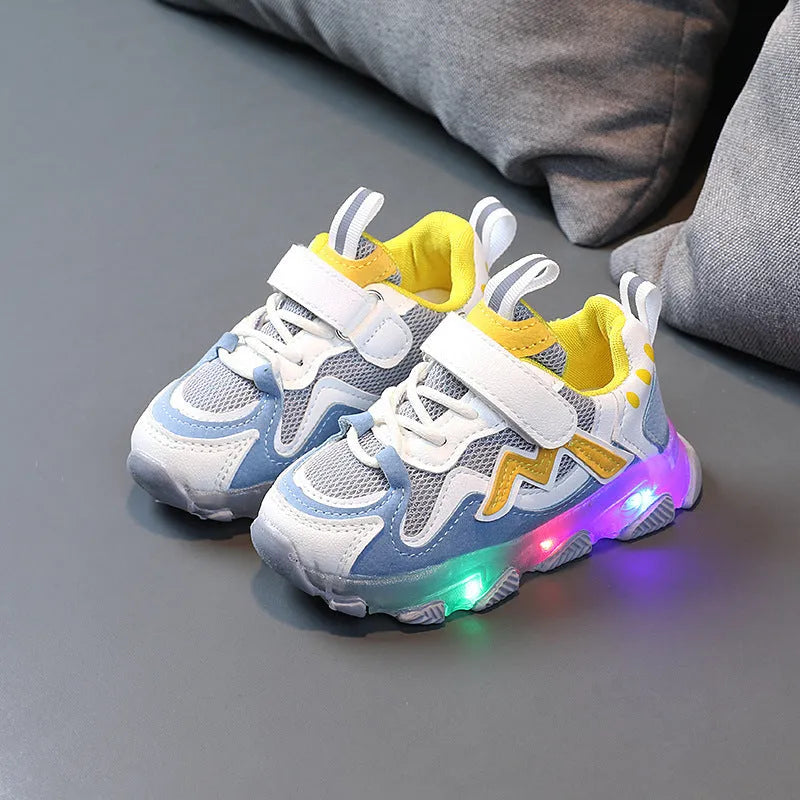 Children's sneakers with Velcro strap, mesh upper panels, and a solid rubber sole in black, grey, or pink.