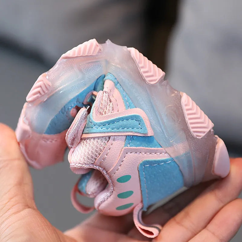 Children's sneakers with Velcro strap, mesh upper panels, and a solid rubber sole in black, grey, or pink.