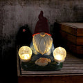 Solar LED resin dwarf doll garden ornament with faceless old man design, shown outdoors.