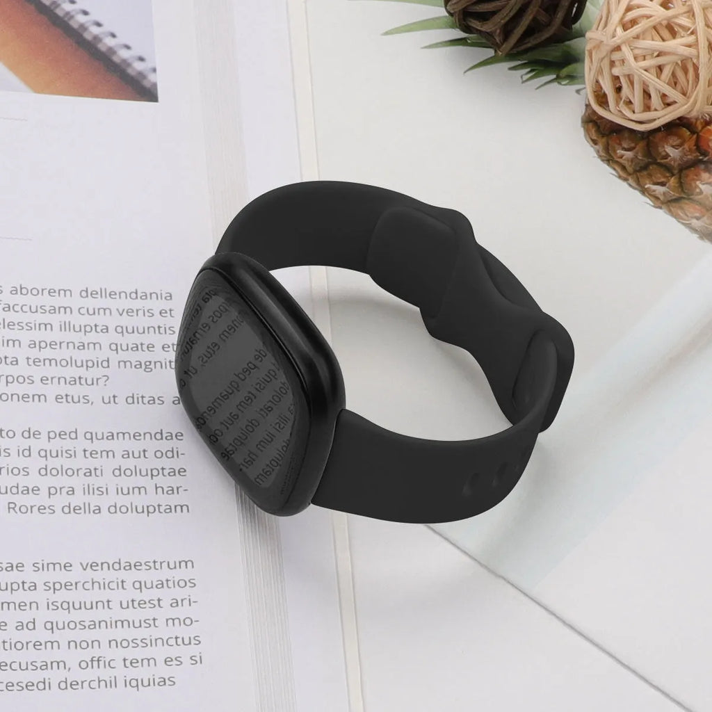 Fitbit Versa3 smart watch with a black TPU silicone replacement strap on a wrist.