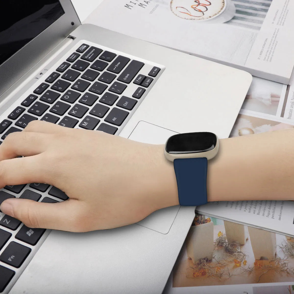 Fitbit Versa3 smart watch with a black TPU silicone replacement strap on a wrist.