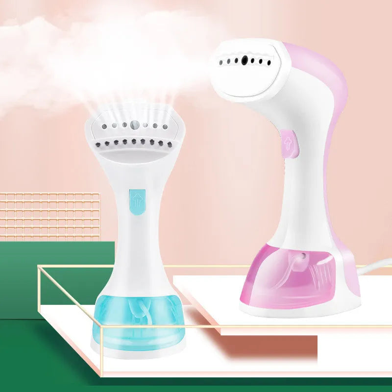 Mini portable handheld garment steamer 1200W in pink with water tank and brush on a wooden surface