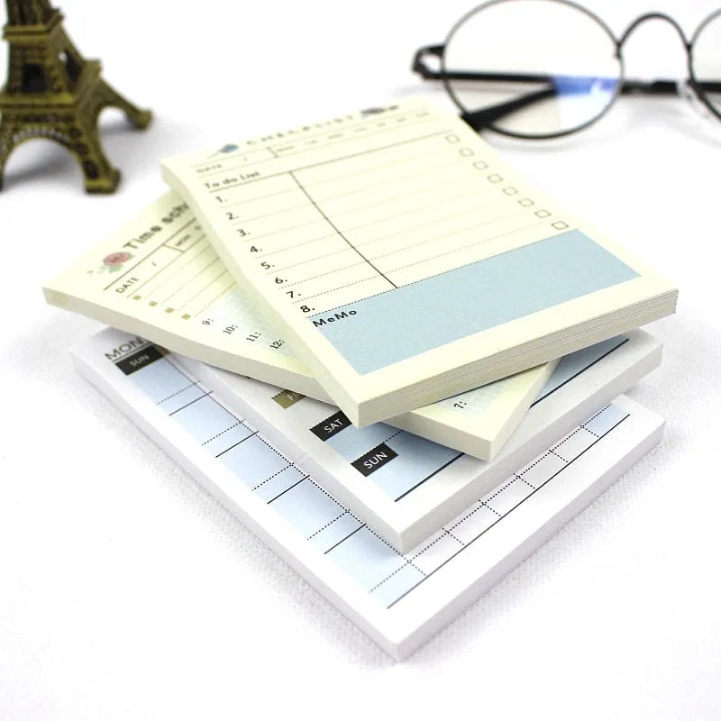 Compact A6 work plan diary notebook open, showing weekly planning pages.