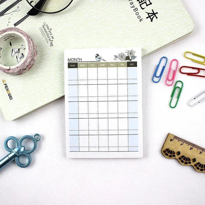 Compact A6 work plan diary notebook open, showing weekly planning pages.