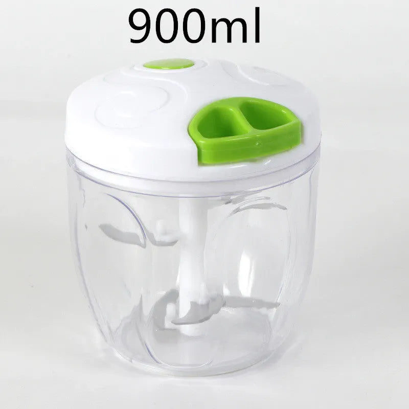 Green manual kitchen chopper with stainless steel blades next to chopped vegetables on a counter.