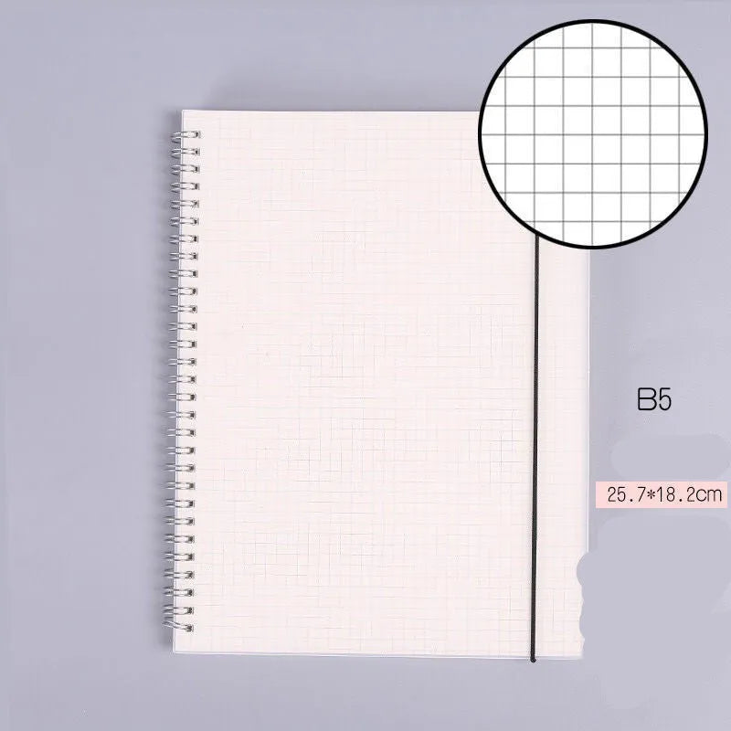 B5 coil grid notebook with Pp cover, open showing lined pages on a desk