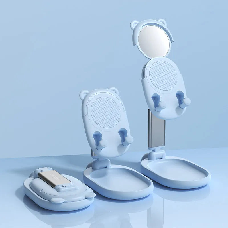 Blue adjustable desk phone holder with mirror, holding an iPhone at an angle on a wooden desk