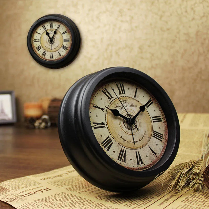Round retro desk alarm clock with a white dial on a wooden surface.