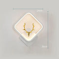 Modern deer antler design wall lamp with remote control on a plain wall, showing white and black colour options.