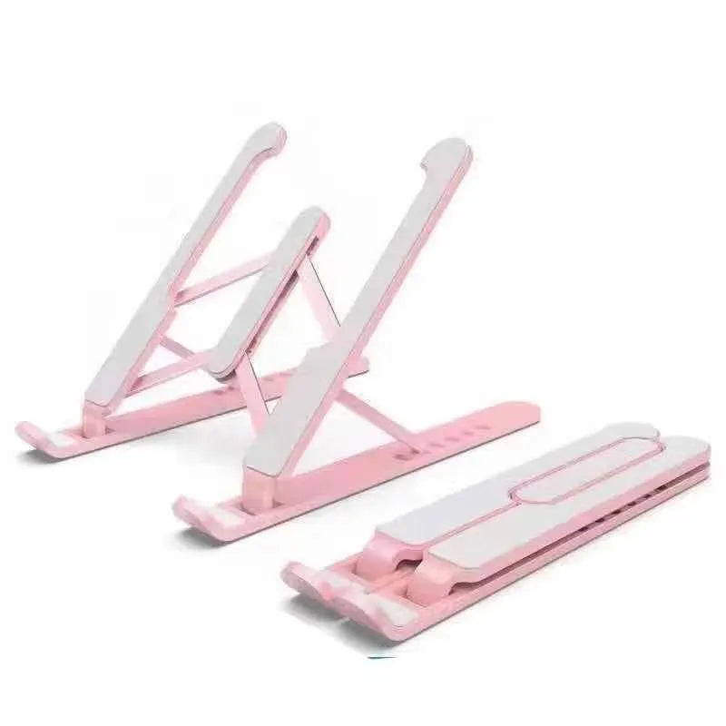 Folding aluminium alloy laptop stand in grey on a wooden desk, showing adjustable width and non-slip pads