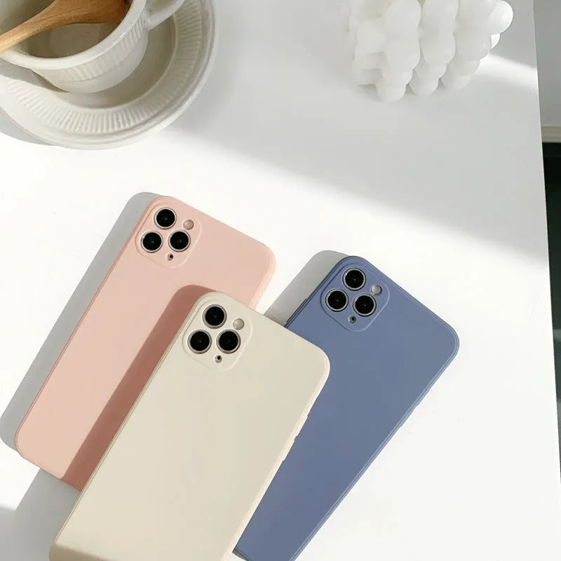 Simple solid colour silicone phone case for iPhone in pink, blue, and antique white options.
