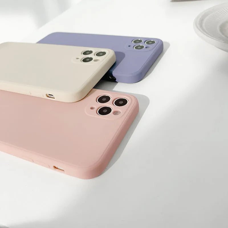 Simple solid colour silicone phone case for iPhone in pink, blue, and antique white options.