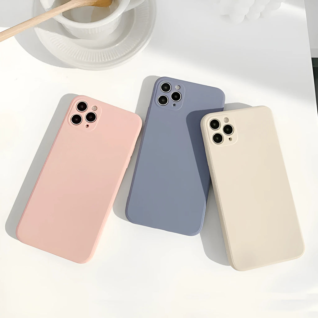 Simple solid colour silicone phone case for iPhone in pink, blue, and antique white options.