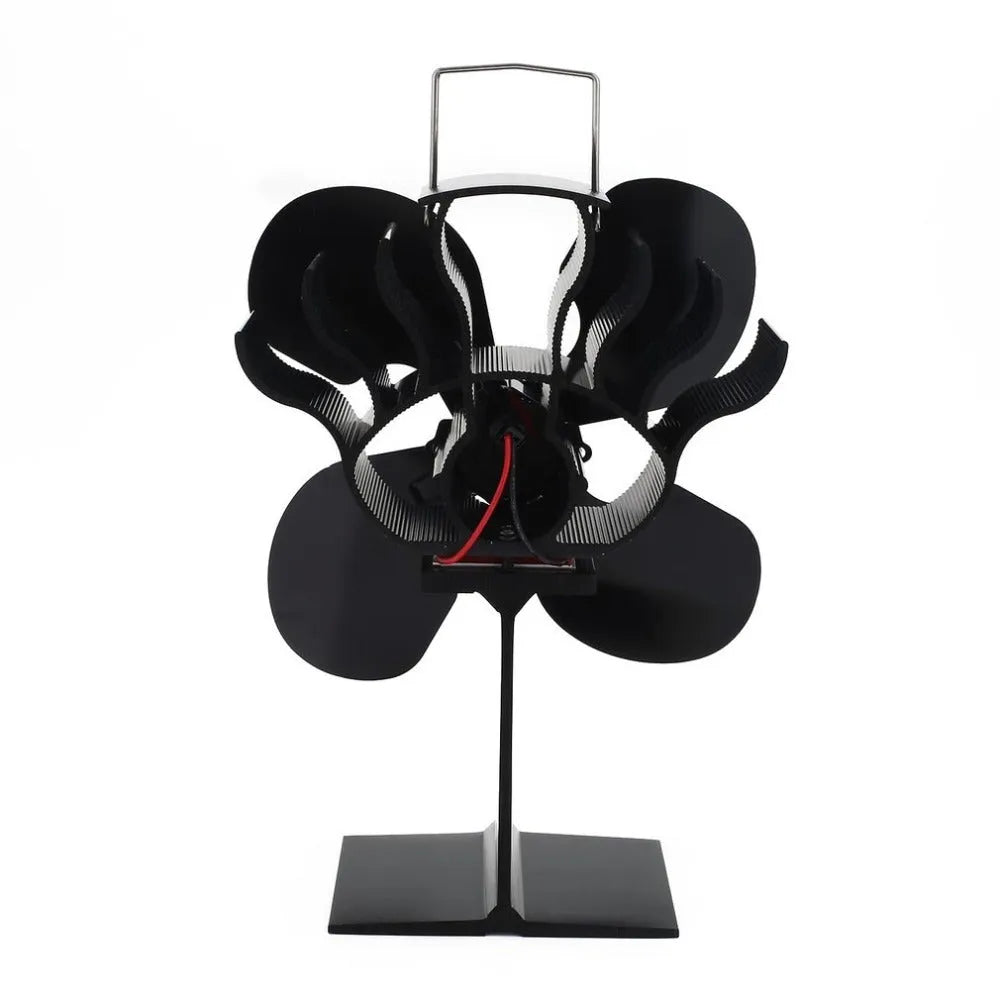 Black Yotsuba style thermodynamic fireplace fan sitting on a hearth.