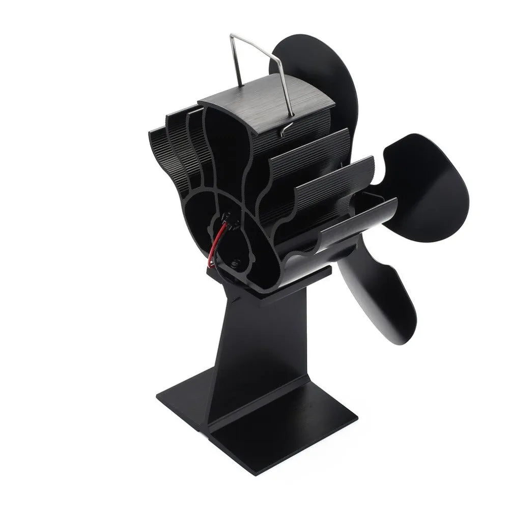 Black Yotsuba style thermodynamic fireplace fan sitting on a hearth.
