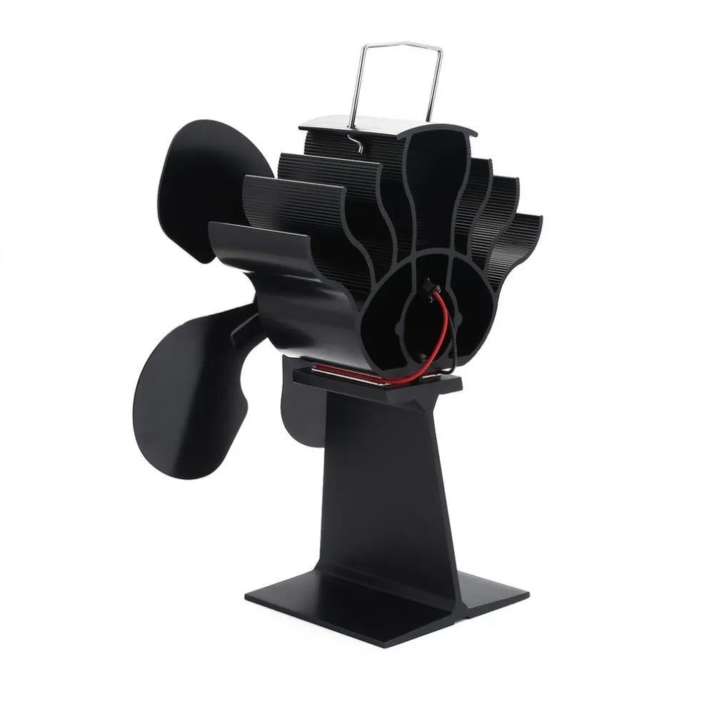 Black Yotsuba style thermodynamic fireplace fan sitting on a hearth.