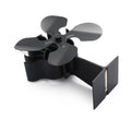 Black Yotsuba style thermodynamic fireplace fan sitting on a hearth.