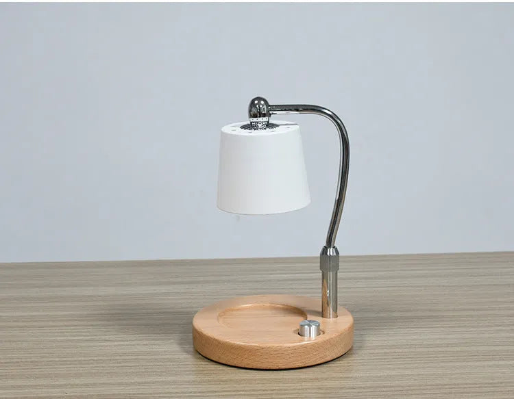 A black wooden aromatherapy wax lamp holding a candle on a bedroom surface.