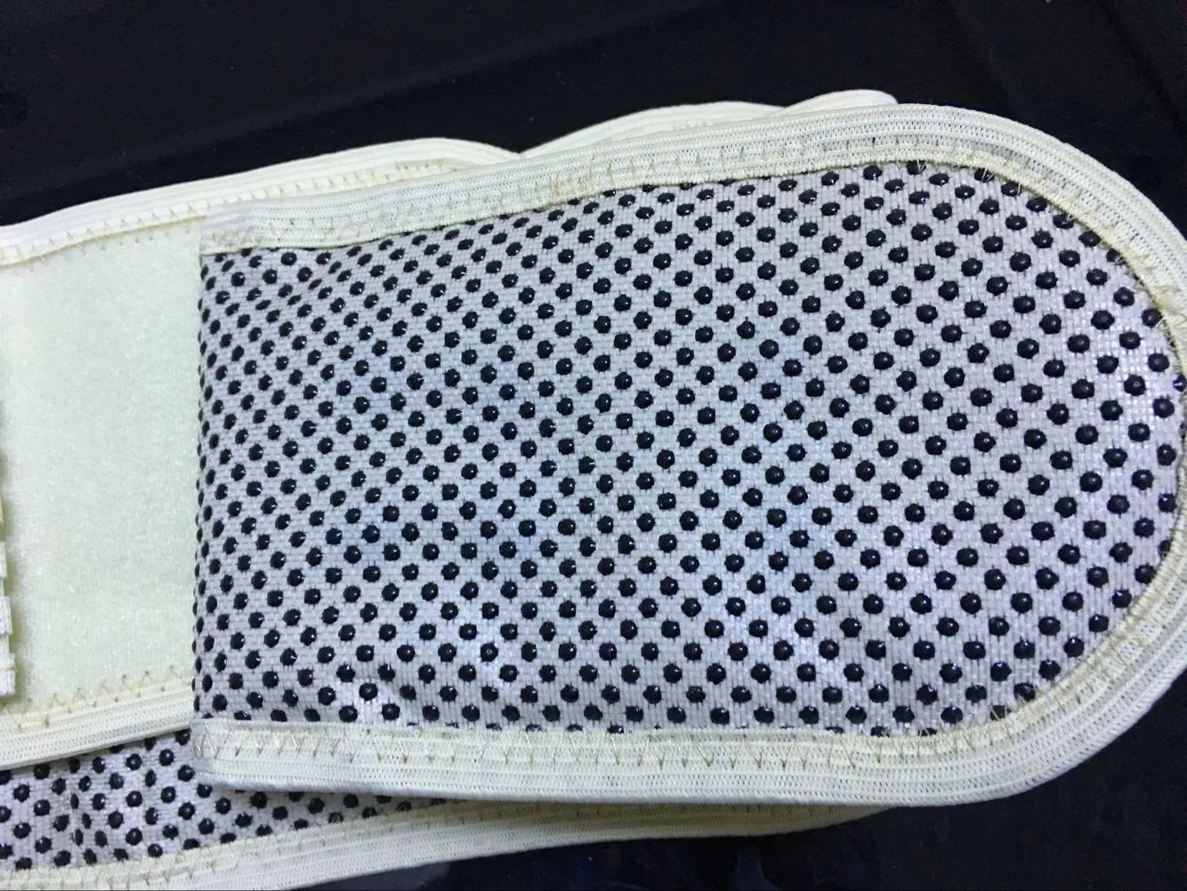 Black self-heating magnetic waist protection belt laid flat, showing its elastic cloth material and fastener.