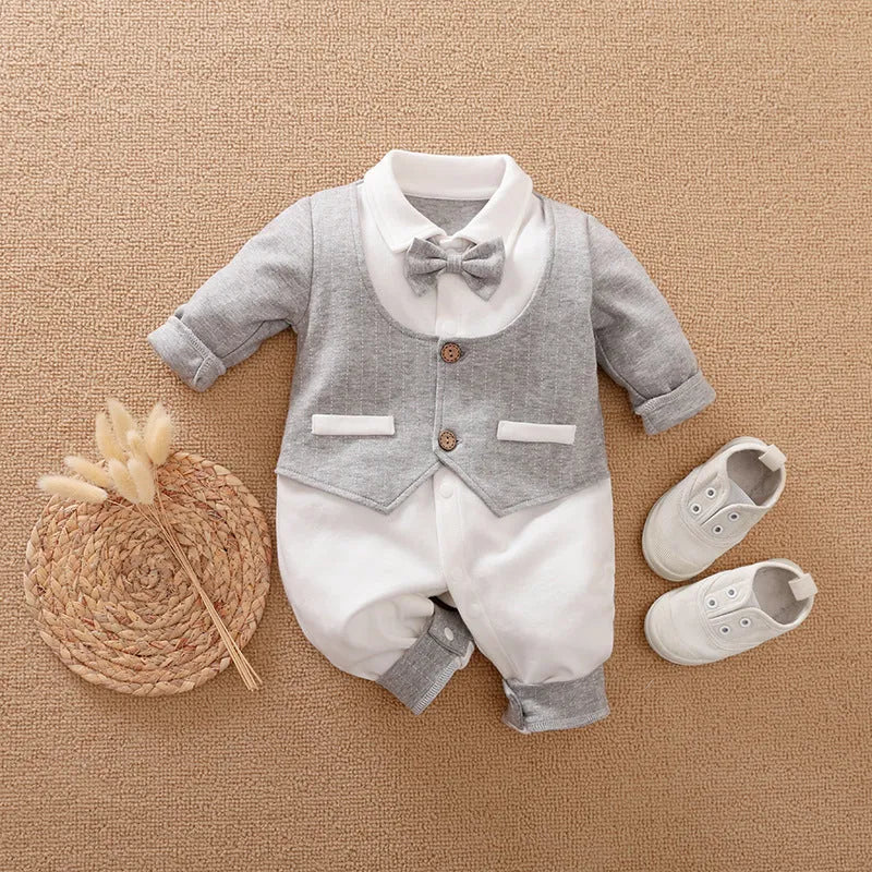 Baby boy wearing a navy blue long-sleeved cotton jumpsuit with gentleman styling.