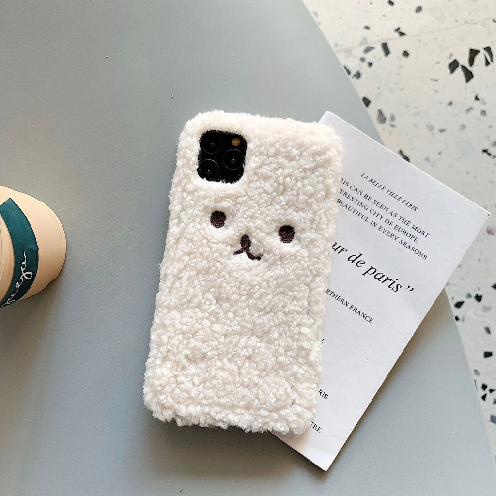 Brown plush embroidered cartoon bear face on a white TPU iPhone case for iPhone 11.