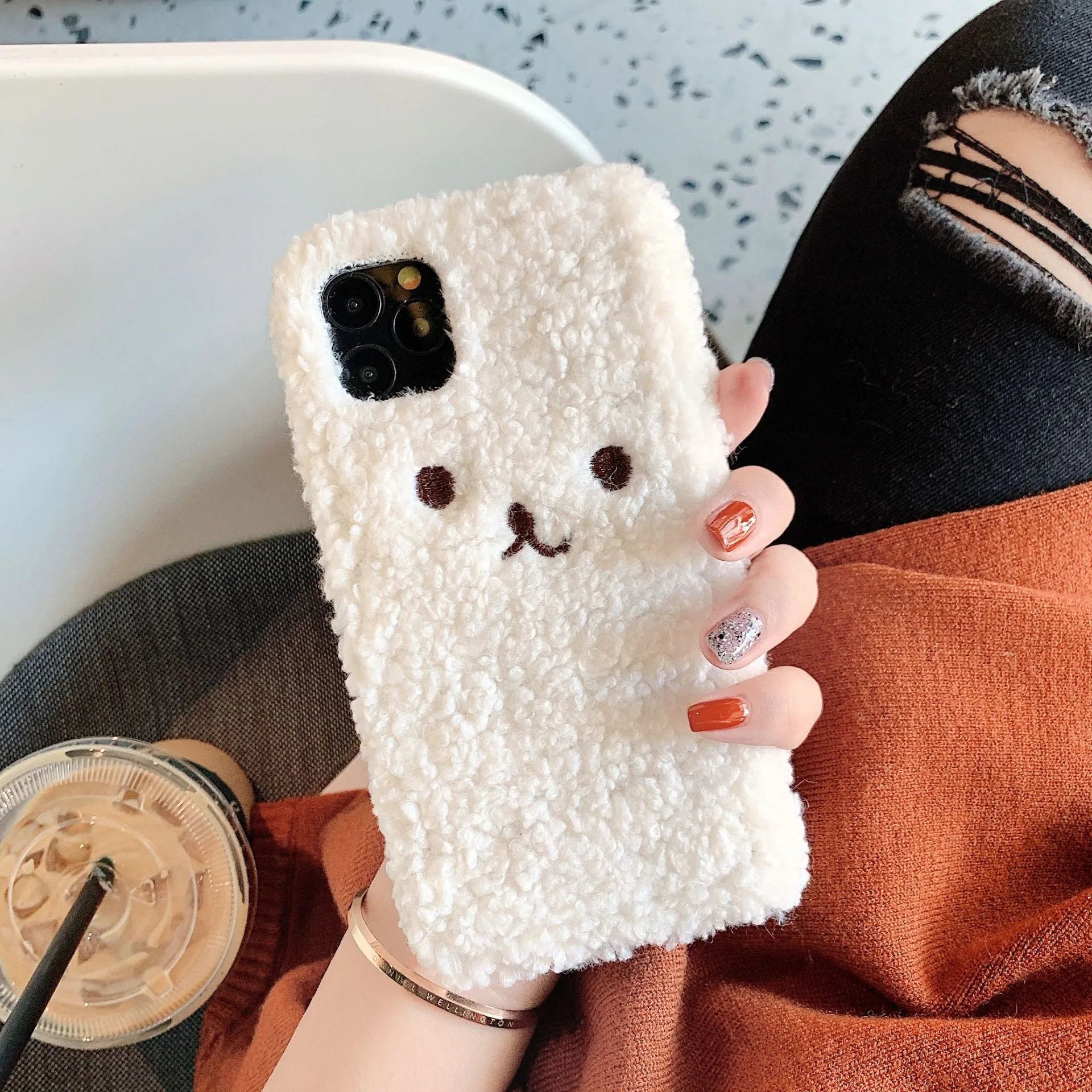 Brown plush embroidered cartoon bear face on a white TPU iPhone case for iPhone 11.