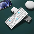 Aluminium folding Bluetooth keyboard with stand holding a smartphone