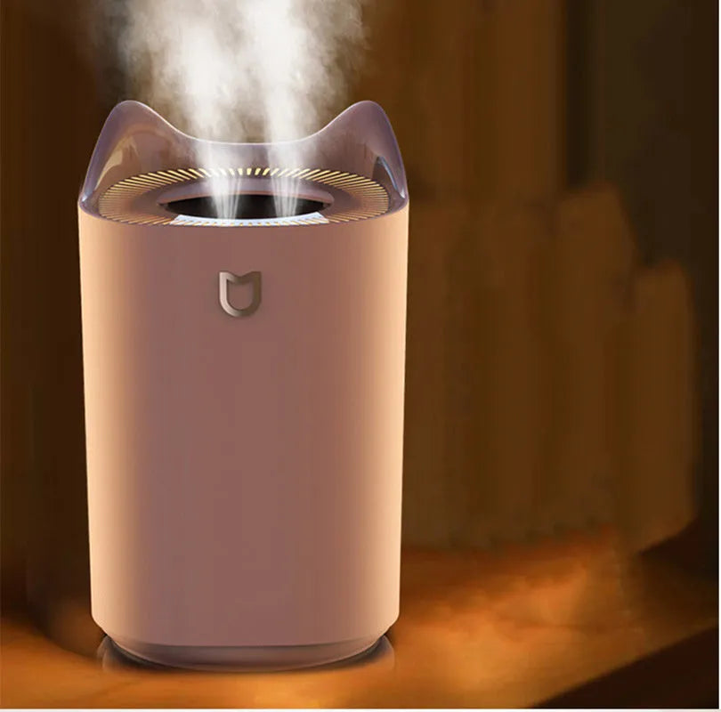 A coral pink and white USB-powered double spray humidifier and aroma diffuser on a table.