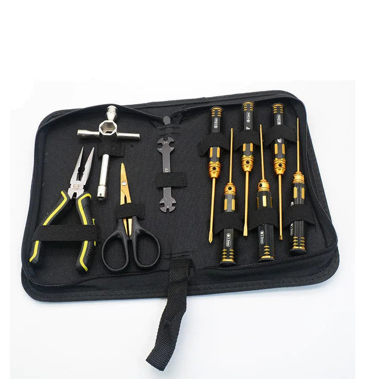 RC model toolkit with titanium-plated screwdrivers, sleeve pliers, scissors, and tool bags on a workbench.