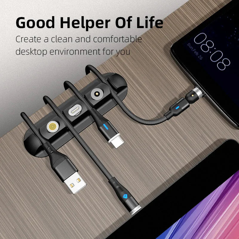 Black soft plastic desktop charging base stand and cable organiser on a desk.