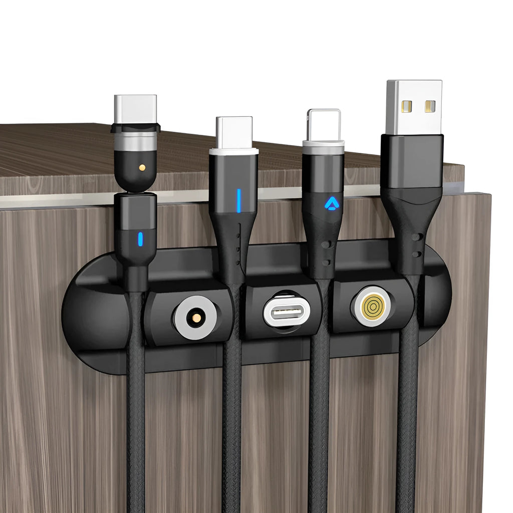 Black soft plastic desktop charging base stand and cable organiser on a desk.