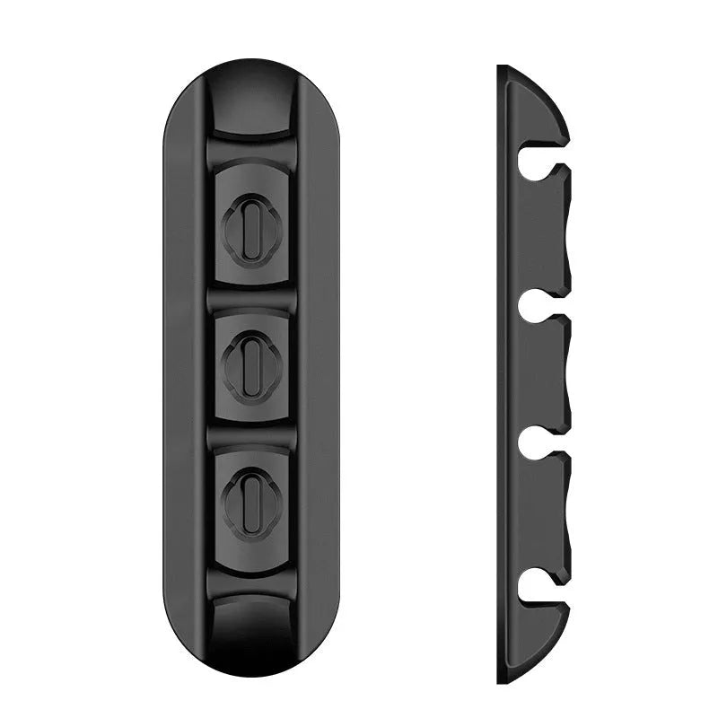 Black soft plastic desktop charging base stand and cable organiser on a desk.