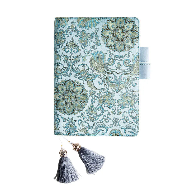 Flying blue flowers pattern fabric cover notebook in A5 and A6 sizes on a desk.