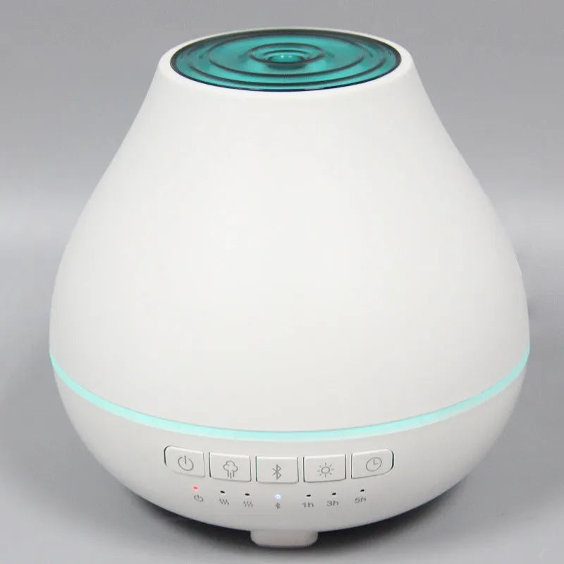 White round Bluetooth aroma diffuser and humidifier unit with night light on a wooden surface.