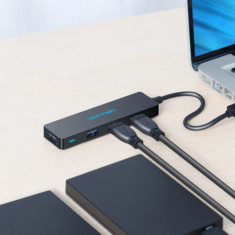 Black four-port USB 3.0 hub with a short cable for expanding laptop and computer connections