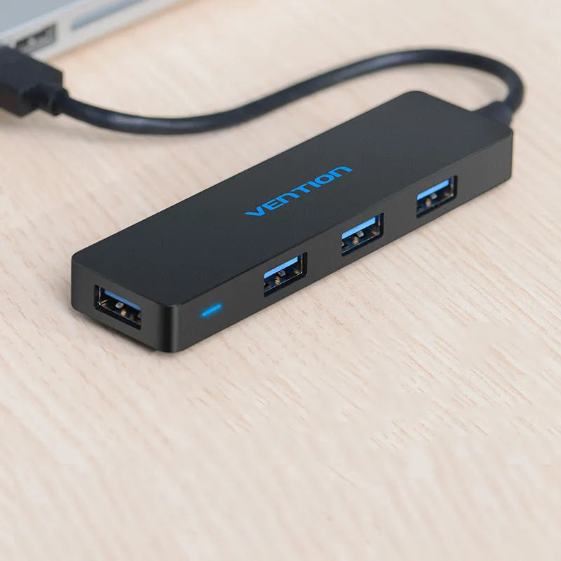 Black four-port USB 3.0 hub with a short cable for expanding laptop and computer connections