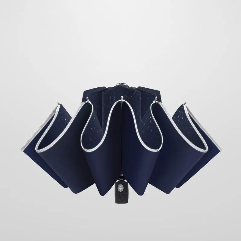 Black automatic reverse folding umbrella with plastic handle, shown closed and demonstrating the reverse mechanism.