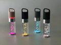 Colourful portable Bluetooth speaker with crystal light and carry handle in pink, black, silver grey, or green.