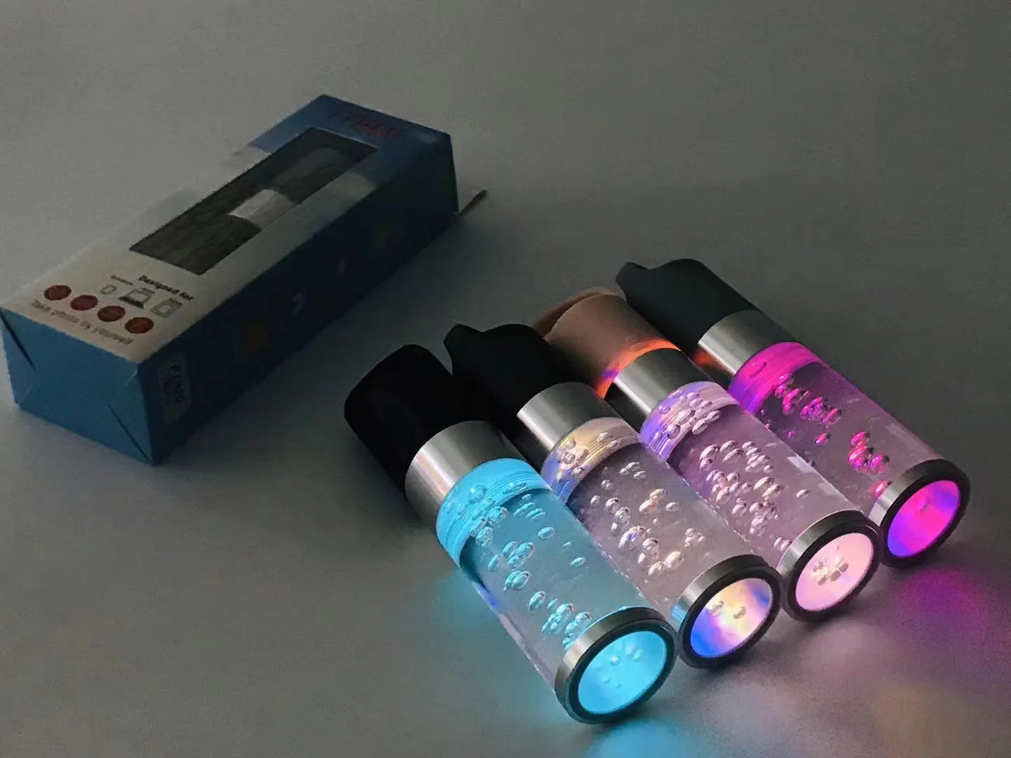 Colourful portable Bluetooth speaker with crystal light and carry handle in pink, black, silver grey, or green.