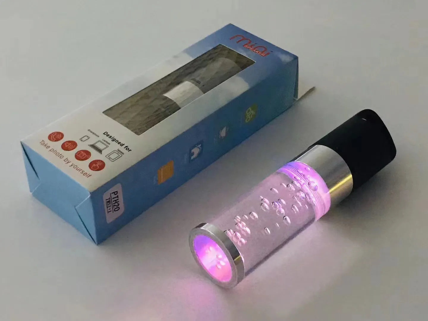Colourful portable Bluetooth speaker with crystal light and carry handle in pink, black, silver grey, or green.