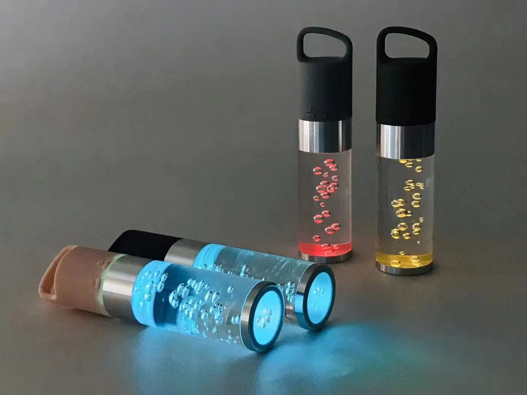 Colourful portable Bluetooth speaker with crystal light and carry handle in pink, black, silver grey, or green.