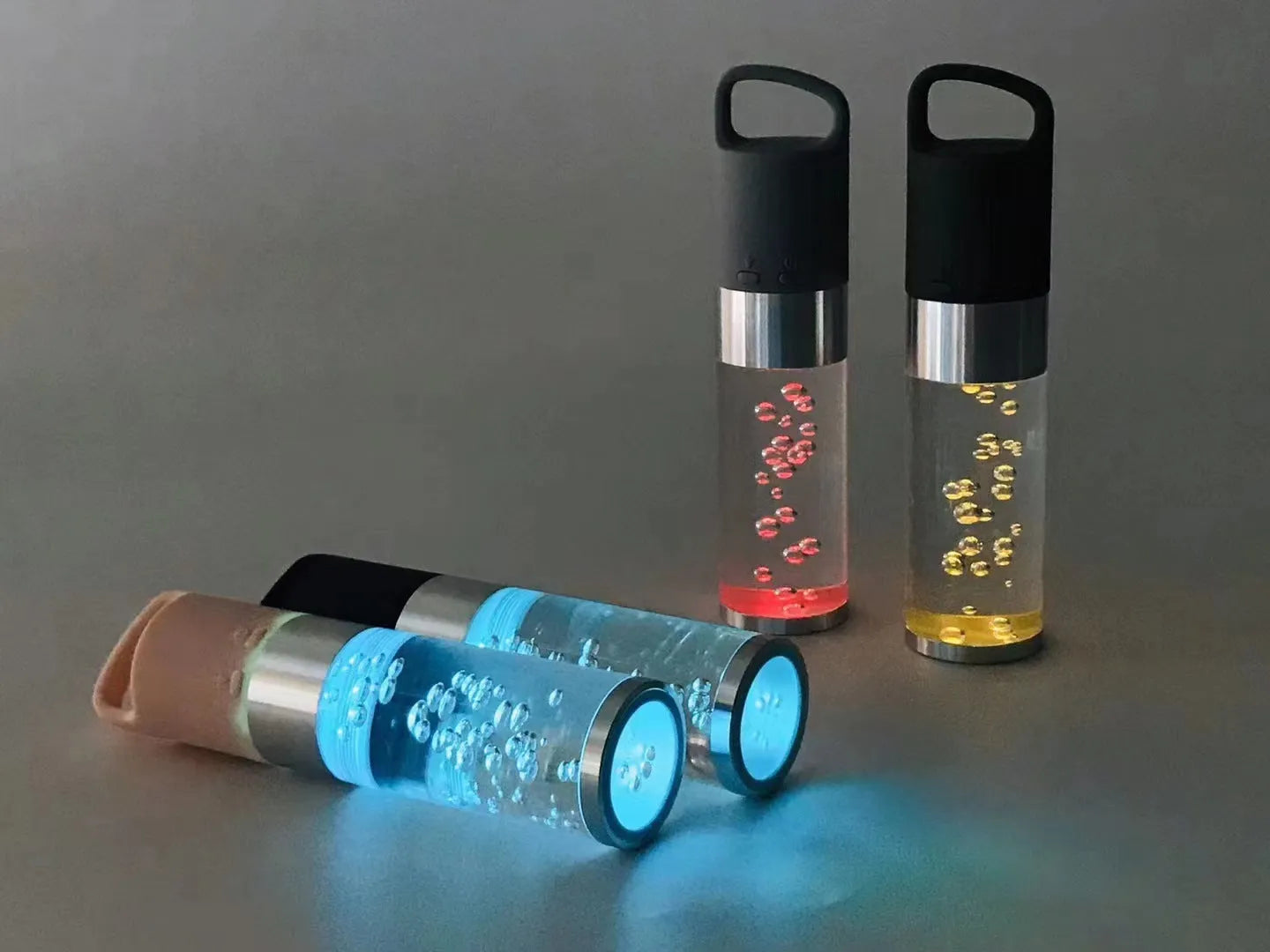 Colourful portable Bluetooth speaker with crystal light and carry handle in pink, black, silver grey, or green.