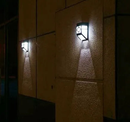 Retro-style white plastic solar wall light with two LEDs and a manual switch on the front.