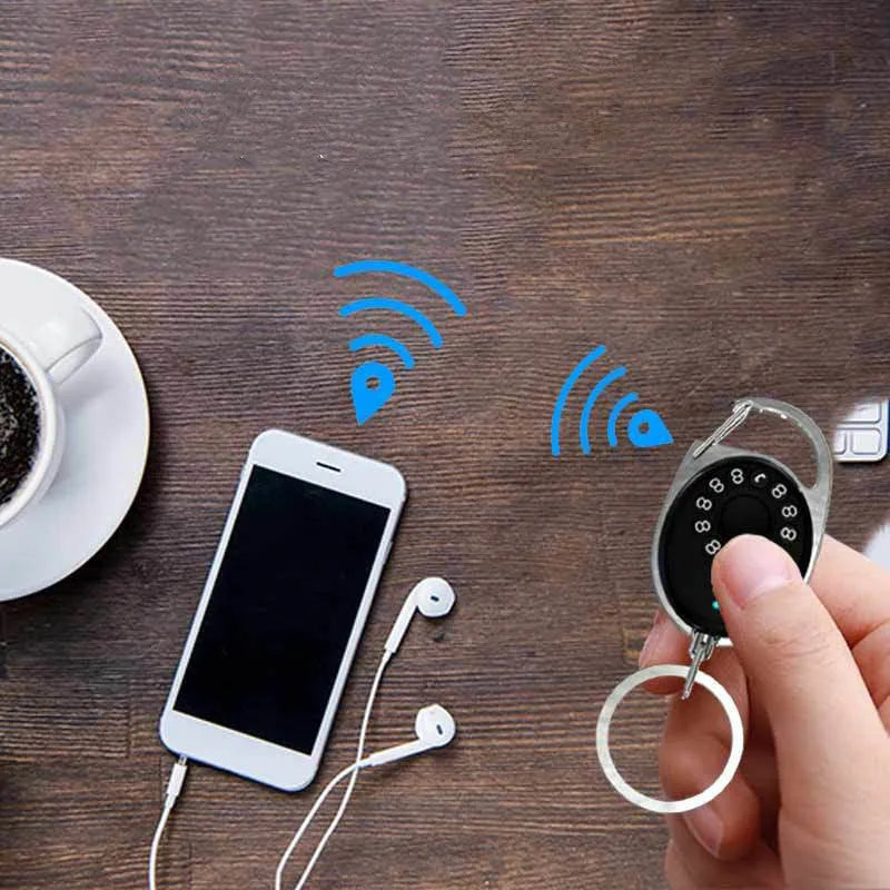 Black Bluetooth anti-lost tracker keychain with selfie function, shown next to keys for scale