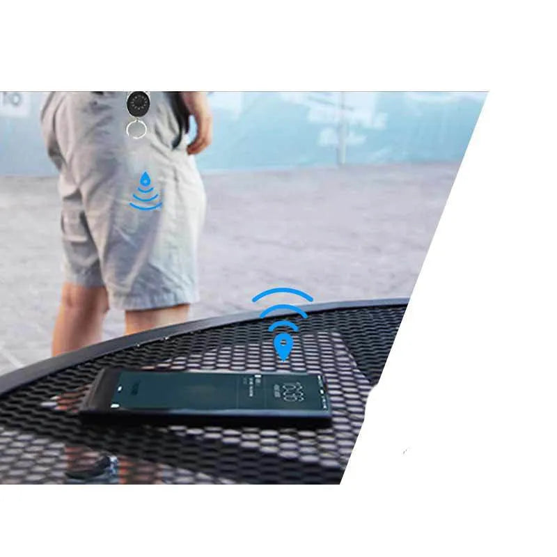 Black Bluetooth anti-lost tracker keychain with selfie function, shown next to keys for scale