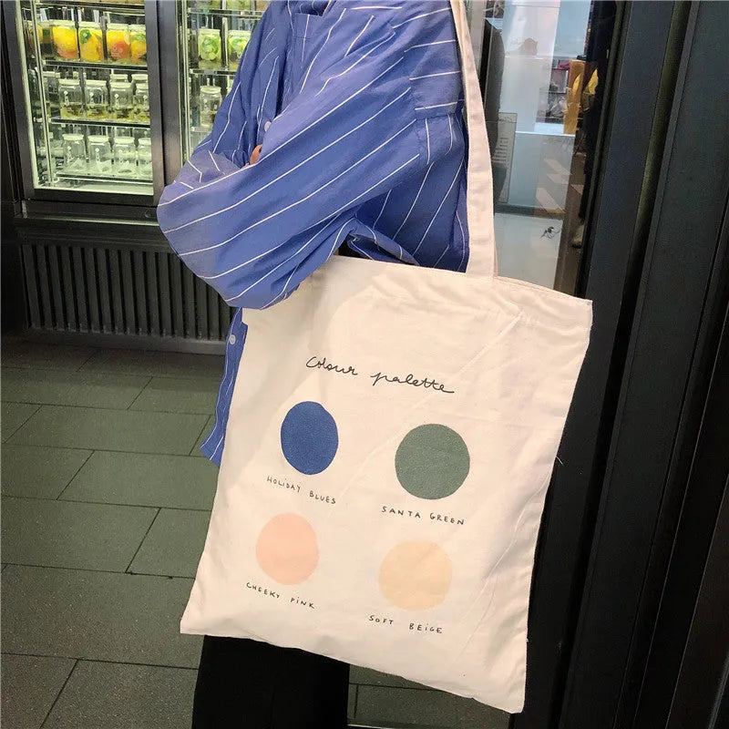 Light pink canvas tote bag with geometric print, showing zipper closure and soft handles.