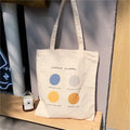 Light pink canvas tote bag with geometric print, showing zipper closure and soft handles.