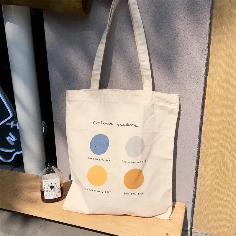 Light pink canvas tote bag with geometric print, showing zipper closure and soft handles.
