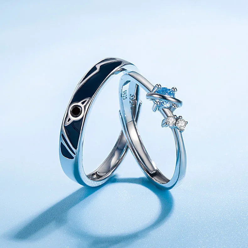 Dream Planet silver geometric couple rings with gem inlay on a flat surface